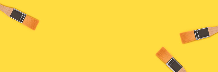 Banner with paint brushes on a yellow background. Artistic creative concept.