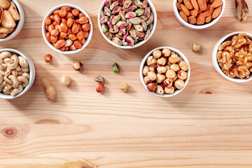 Nuts assortment, shot from above on a wooden background with copy space