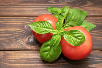 Tomatoes with basil on a wooden background. Food composition. top view