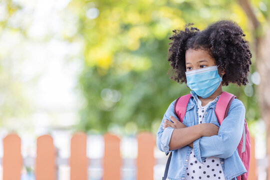 Childhood And Back To School - Little African American Curly Hair Girl Wearing Face Mask To Protect Virus And Worried Look On His Face After Going Back To School Again.