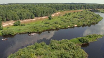 Tracking a Boat. Tourist base of kayaks and canoes, summer adventure kayak, rafting to canoe. Kayaking top view. Group of kayaks rowing together. Aerial view from drone.