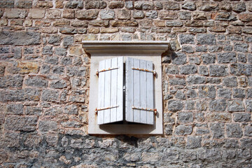 Old wooden window with white shutters of an mediterranean house, vintage background