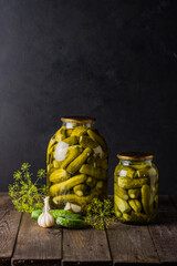 Pickled cucumbers in the jar. Ingredients for pickling cucumbers. Cucumbers, dill, garlic. Glass jars with pickles
