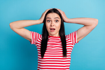 Photo of shocked amazed surprised young woman hold hands head having problem trouble isolated on blue color background