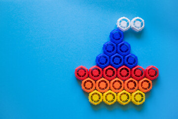 Plastic lids from baby puree in the form of a boat on a blue background. Ecology, copy space