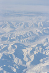 Aerial view of snow-capped mountains. Winter snowy mountain landscape. Travel to the far north of Russia. Kolyma Mountains, Magadan Region, Siberia, Russian Far East. Great for the background.