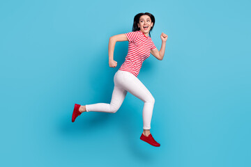 Full length profile side photo of young girl happy positive smile jump go run hurry sale isolated over blue color background