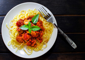 Chicken Spaghetti with Tomato Sauce on a Dark Wooden Floor