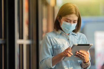 Asian woman wear face mask using tablet technology, Mask to protect covid19 coronavirus, COVID-DELTA ,COVID-ALFA