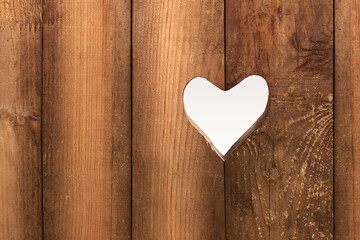 Heart on brown wooden background. Love concept. Rustic background. Carved heart in a old wooden wall. Valentine's Day