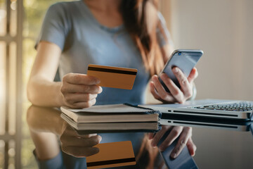 Hands holding credit card and using laptop in office home. Online shopping.