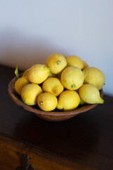 A Rustic Ceramic Bowl of Lemons on a Wooden Table