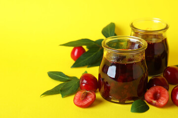 Cherry jam and ingredients on yellow background