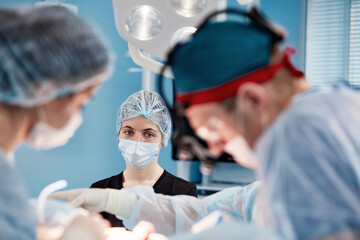 View from below of four multi ethnic surgeons in protective work wear during operation