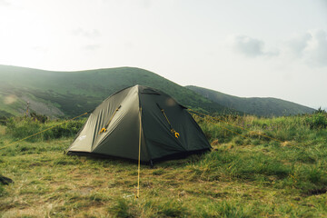 Camping tent in campground at national park. Tourists camped on the carpathian mountains. View of tent on meadow in forest.