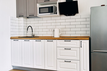 White cabinets with wooden counter of modern kitchen