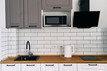 White cabinets with wooden counter of modern kitchen