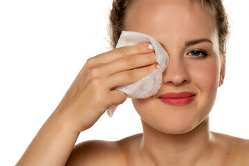 portrait of a blonde beautiful smiling woman cleans makeup from her face with a wet wipe