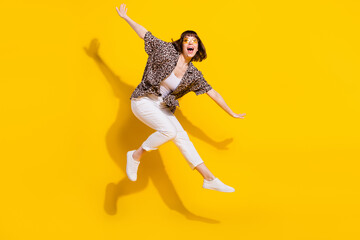 Fototapeta na wymiar Full length body size view of pretty funny cheerful girl jumping having fun like plane isolated bright yellow color background