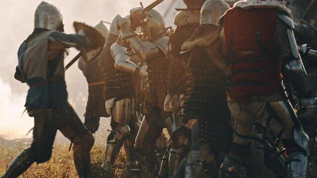 Epic Armies of Medieval Knights on Battlefield Clash, Plate Body Armored Warriors Fighting Swords in Battle. Bloody War and Savage Conquest. Historical Reenactment. Cinematic Medium