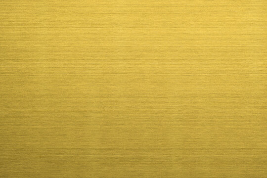 Shiny gold polished metal background texture of brushed stainless steel plate with the reflection of light.