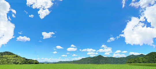 真っ青な透き通った空と草原と山　パノラマ