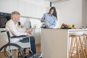 Gray-haired handicapped man and his wife at home before breakfast