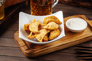 Plate of fried chebureks meat stuffed pies on wooden background