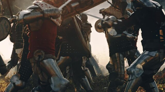 Ancient Armies of Medieval Knights Fighting with Swords in Battle. Epic Battlefield Attack, Plate Body Armored Warriors in Bloody War and Savage Conquest. Historical Reenactment. Cinematic Slow Motion