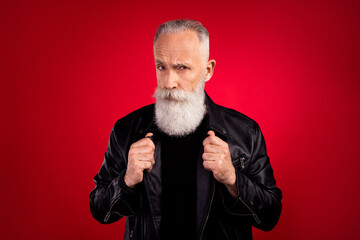 Photo of self-assured bearded old man serious challenging look camera wear leather jacket isolated on red color background