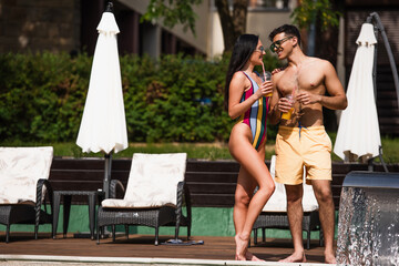 Happy couple with takeaway drink standing near fountain during vacation