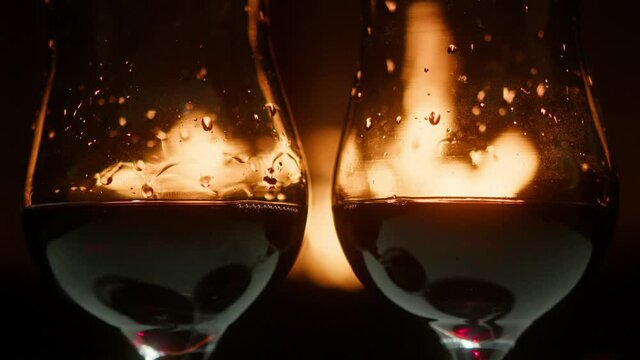 Two glasses of red wine on bonfire background. Alcoholic beverage in a glass.