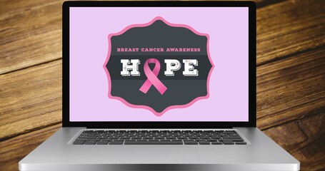 Composition of pink ribbon logo and breast cancer text on the laptop screen