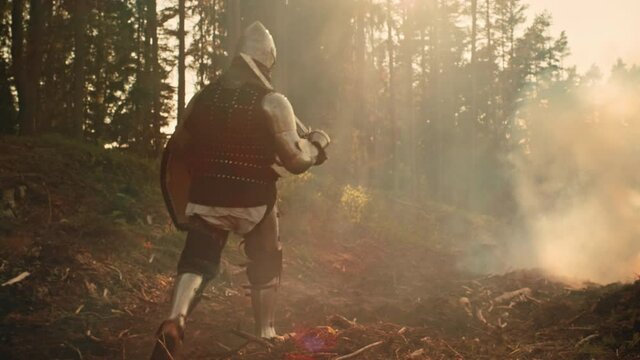 Lonesome Medieval Warrior Marching Through Forest. Last Surviving Crusader, Soldier, Knight Wearing Full Body Armor, Helmet, Shield and Sword Traveling Through Mysterious Land He Invaded to Colonise