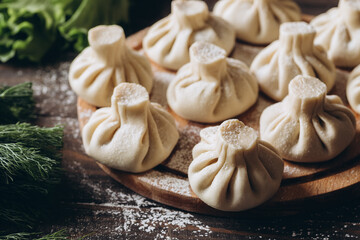 Georgian homemade dumpling or khinkali on cutting wooden board.