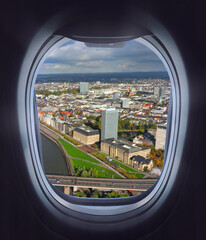 Fototapeta na wymiar Looking through the airliner window out. Beautiful scenic overhead airplane view of Dusseldorf City and Rhine river. Flying over the Northern Rhine Westphalia, Germany