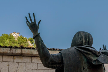 Fototapeta premium The statue of Santa Rita da Cascia facing Rock of Prayer of Roccaporena, Cascia, Italy, or Sacro Scoglio