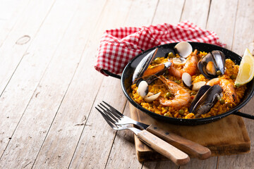 Traditional spanish seafood paella on wooden table. Copy space