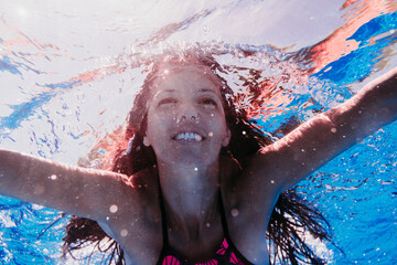 happy caucasian woman diving in swimming pool. underwater view. Summer time and vacation concept