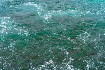 Beautiful turquoise ocean waves with rocks