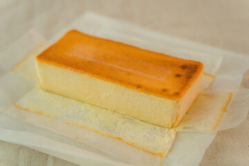 リネンのテーブルクロスに置かれたベイクドチーズケーキ一本