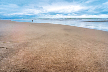 Striped sand on a California beach. Golden sand with an admixture of black sand. Pattern on the sand from the wind