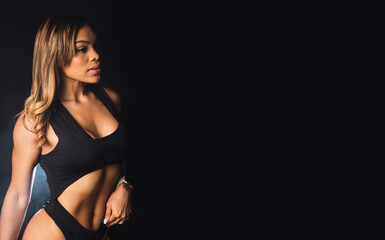 Fototapeta premium Portrait of a young Latina sportswoman on a black background.