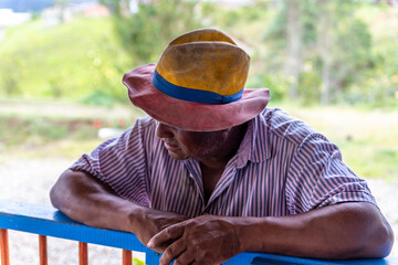 portrait of a Colombian peasant leaning against a wooden railing