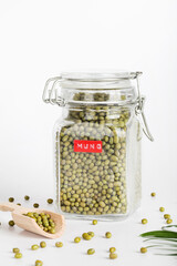 mung in glass jar with wooden spoon on white background. healthcare lifestyle and organic food concept.