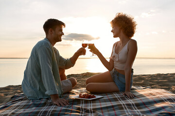 Smiling young caucasian couple drinking red wine