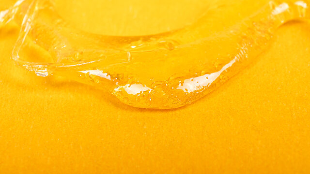 piace golden dab concentrate of cannabis wax close up on yellow background, marijuana resin