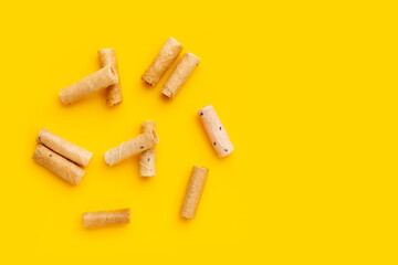 Thai crispy coconut rolls on yellow background.