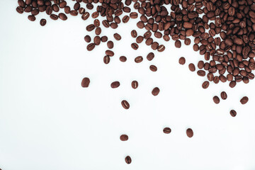 Aromatic dark brown coffee beans isolated on white background. Top view with copy space. Coffee...