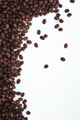 Aromatic dark brown coffee beans isolated on white background. Top view with copy space for your text. Vertical